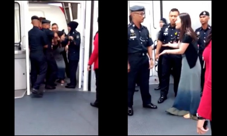 Empat petugas pria dan perempuan menarik wanita China itu karena memaksa membuka pintu pesawat