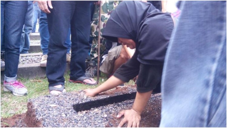 Seorang warga Zeni Mampang mencoba membongkar makam ayahnya di TMP Kalibata